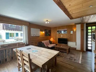 a living room with a wooden table and a couch at Spacious 2 bedroom apt with terrace Chamonix center in Chamonix-Mont-Blanc