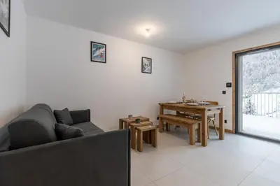 a living room with a couch and a table at Le Manoir de Kayla - Piscine, Sauna & Vue in Les Houches