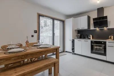 a kitchen with a wooden table and a tableasteryasteryasteryasteryasteryasteryastery at Le Manoir de Kayla - Piscine, Sauna & Vue in Les Houches