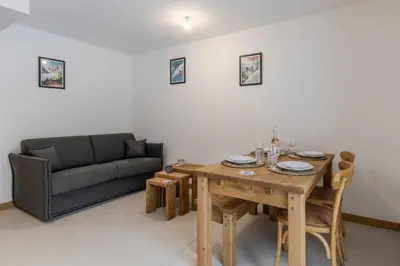 a living room with a table and a couch at Le Manoir de Kayla - Piscine, Sauna & Vue in Les Houches