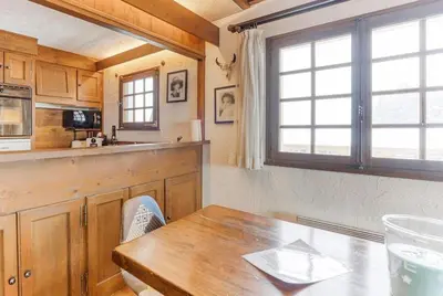 a kitchen with a wooden table and a window at L'Etoile de Megève in Megève