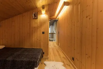 a bedroom with a bed in a wooden wall at L'Etoile de Megève in Megève