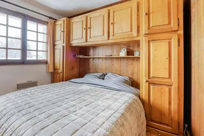 a bedroom with a bed and wooden cabinets at L'Etoile de Megève in Megève