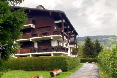a building on a hill with a path in front at L'Etoile de Megève in Megève