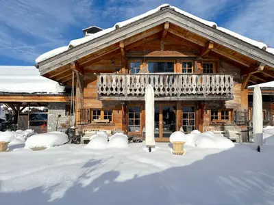 a log cabin with a balcony in the snow at Chalet Hermine in Megève