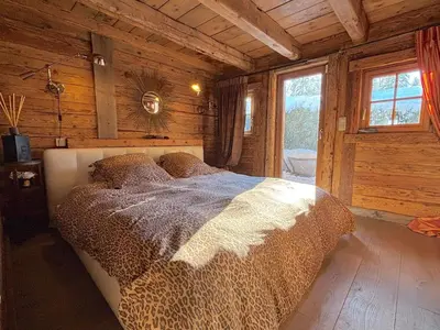 a bedroom with a bed in a wooden cabin at Chalet Hermine in Megève