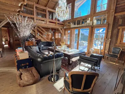 a living room with a leather couch and a table at Chalet Hermine in Megève