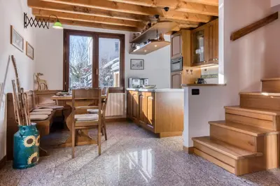 a kitchen with a table and chairs and a counter at Chalet la Chouette - Intimate 2 bedroom demi-chalet ideally located in Chamonix-Mont-Blanc