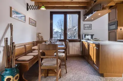 a kitchen with a table and chairs in a room at Chalet la Chouette - Intimate 2 bedroom demi-chalet ideally located in Chamonix-Mont-Blanc