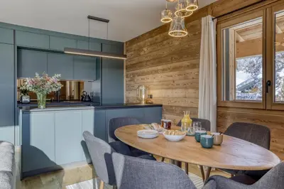 a kitchen and dining room with a table and chairs at L'Alezan I Appartement proche du centre de Megève in Megève