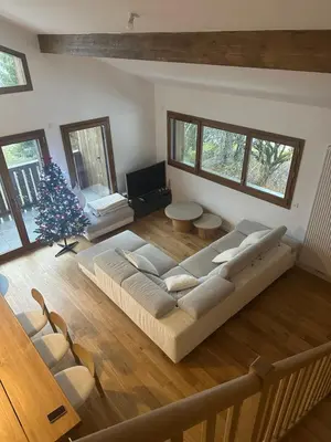 a living room with a large couch and a christmas tree at L'écrin de Samoëns in Samoëns