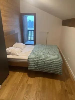 a bed in a room with a large window at L'écrin de Samoëns in Samoëns