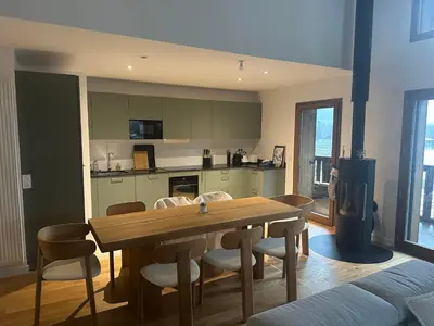 a kitchen and dining room with a wooden table and chairs at L'écrin de Samoëns in Samoëns