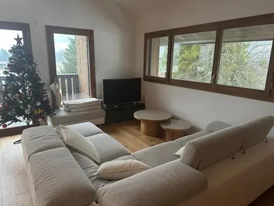 a living room with a couch and a christmas tree at L'écrin de Samoëns in Samoëns