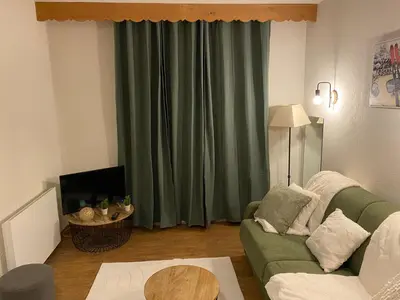 a living room with a green couch and a table at Appartement pour 6 personnes au pied du téléphérique in Saint-Gervais-les-Bains