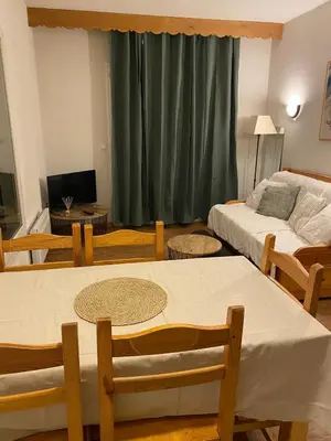 a room with two beds and a table and chairs at Appartement pour 6 personnes au pied du téléphérique in Saint-Gervais-les-Bains