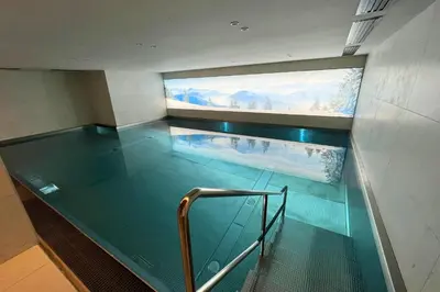 a swimming pool with a glass floor in a building at Appartement Montalis - Welkeys in Megève