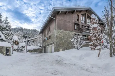 a home in the winter with snow around it at Appartement Montalis - Welkeys in Megève