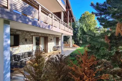 a house with a deck and a patio at Appartement Montalis - Welkeys in Megève