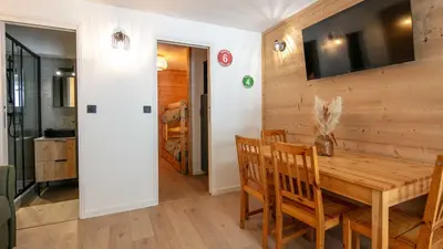 a dining room with a wooden table and chairs at Grand Tetras N111 2P6 in Morillon