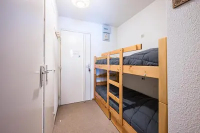 a bedroom with two bunk beds and a door at Le Cocon des Pistes - Station à 10 minutes in Les Contamines-Montjoie