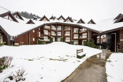 a building covered in snow with snow covered roofs at Le Cocon des Pistes - Station à 10 minutes in Les Contamines-Montjoie
