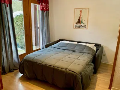 a bed in a room with a large window at Le Cocon des Pistes - Station à 10 minutes in Les Contamines-Montjoie