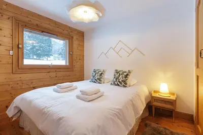 a bedroom with a white bed with towels on it at Le Hameau des Glaciers - Ski & Vue Incroyable in Les Houches