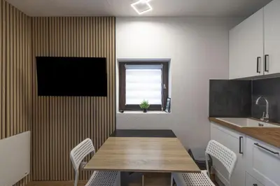 a kitchen with a table and a television on a wall at Cozy Apartment In Morillon in Morillon
