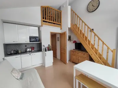 a kitchen with white cabinets and a clock on the wall at Les Eterlous N44 2P6 in Morillon