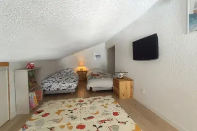 a bedroom with two beds and a flat screen tv at Les Eterlous N44 2P6 in Morillon