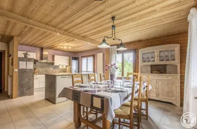 a kitchen and dining room with a table and chairs at L'Arbaz in Samoëns