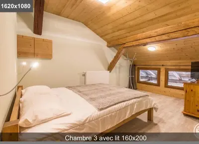a bedroom with a bed in a room with wooden ceilings at L'Arbaz in Samoëns