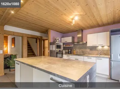 a kitchen with white cabinets and a counter top at L'Arbaz in Samoëns