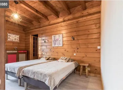 a bedroom with a bed in a wooden wall at L'Arbaz in Samoëns