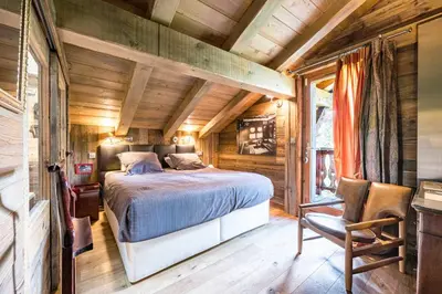 a bedroom with a bed in a wooden house at Luxury Stay Comfortable Chalet with Jacuzzi in Megève