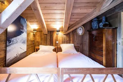 two beds in a room with wooden walls at Luxury Stay Comfortable Chalet with Jacuzzi in Megève