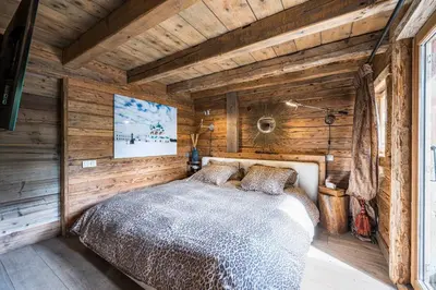 a bedroom with a bed in a wooden wall at Luxury Stay Comfortable Chalet with Jacuzzi in Megève