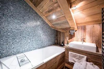 a bathroom with a bath tub and a sink at Luxury Stay Comfortable Chalet with Jacuzzi in Megève