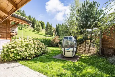a robot sitting in the grass in a yard at Luxury Stay Comfortable Chalet with Jacuzzi in Megève