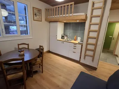 a kitchen and dining room with a table and a loft bed at Appartement central avec grande terrasse Sud pour 4 personnes - FR-1-836-61 in Arâches-la-Frasse