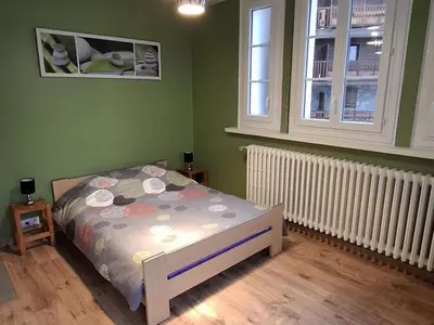 a bedroom with a bed and two windows at Appartement central avec grande terrasse Sud pour 4 personnes - FR-1-836-61 in Arâches-la-Frasse