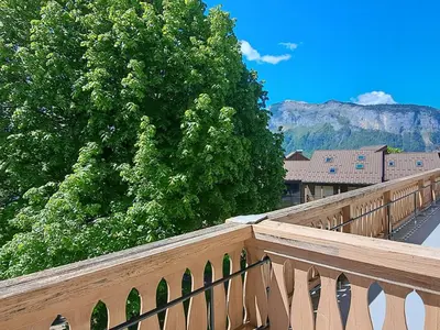 a wooden bridge with trees and a mountain in the background at Appartement central avec grande terrasse Sud pour 4 personnes - FR-1-836-61 in Arâches-la-Frasse