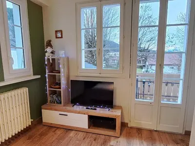 a living room with a tv and some windows at Appartement central avec grande terrasse Sud pour 4 personnes - FR-1-836-61 in Arâches-la-Frasse