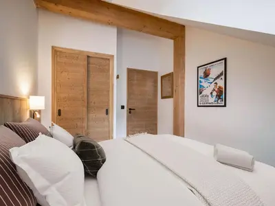 a bedroom with a white bed and two open doors at Appartement moderne Saint-Gervais 6 pers, proche remontées mécaniques - FR-1-663-58 in Saint-Gervais-les-Bains