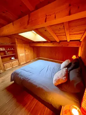 a large bed in a room with a wooden ceiling at Le Montagnard in Saint-Gervais-les-Bains