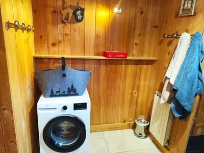 a washer and dryer in a bathroom with wooden walls at Le Montagnard in Saint-Gervais-les-Bains