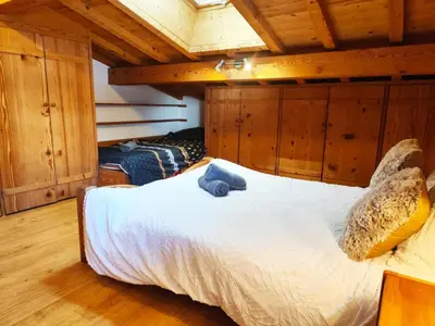a bedroom with a bed with a teddy bear on it at Le Montagnard in Saint-Gervais-les-Bains