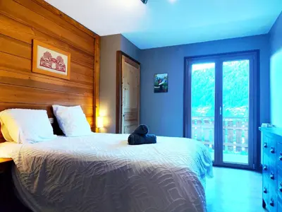 a bedroom with a bed with a teddy bear on it at Le Montagnard in Saint-Gervais-les-Bains