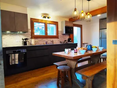 a kitchen with a wooden table and a kitchen counters at Le Montagnard in Saint-Gervais-les-Bains